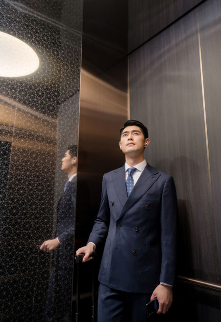 Man in a suit with luggage in an elevator - KONE